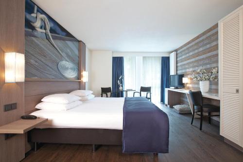 una camera d'albergo con un letto grande e una scrivania di Hotel Medemblik a Medemblik