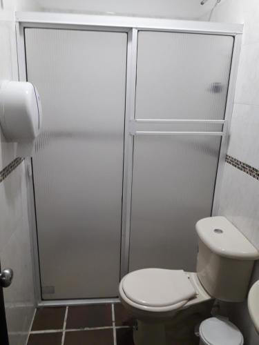 a bathroom with a toilet and a shower stall at Hotel Valle de Beraca in Cúcuta