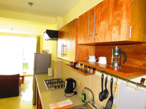 a kitchen with wooden cabinets and a counter top at Boulevard 251 Riverside Apartments in Iquitos
