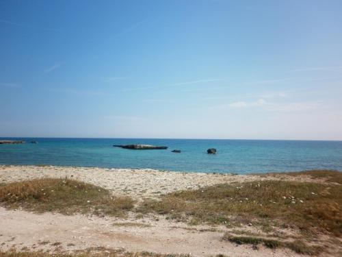 a beach with some rocks in the water at Villino sul mare in San Foca