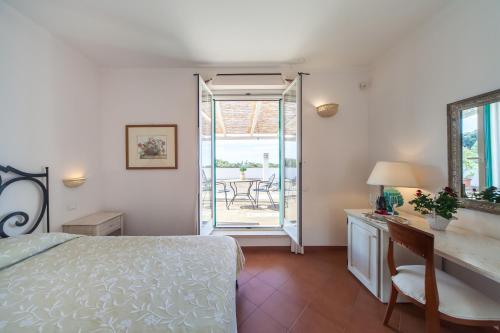 a bedroom with a bed and a desk with a mirror at Villa Carenza in Monopoli