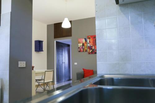 a kitchen with a stainless steel sink and a table at Bahlara Case Vacanza in Palermo