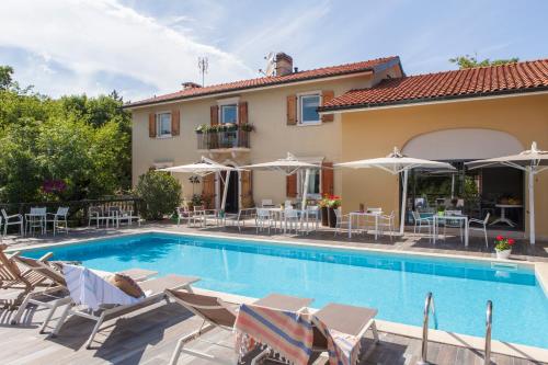 杜伊諾的住宿－博爾戈杜伊諾別墅酒店，别墅设有游泳池和庭院家具。