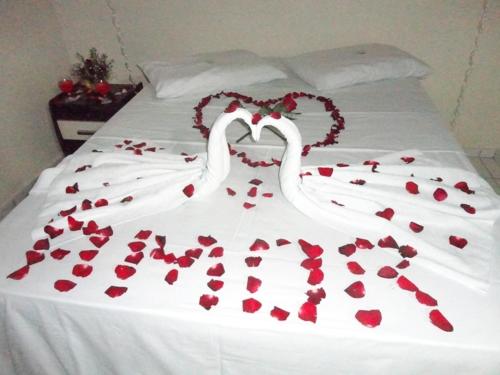 two white swans made out of hearts on a bed at Pousada Max in Currais Novos