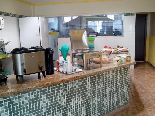 ジョアン・モンレヴァデにあるBrasil Center Hotelの食べ物が置かれたカウンターのあるキッチン