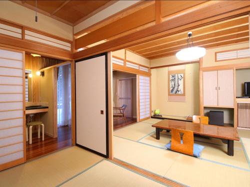 a living room with a table and a dining room at Kamei no Yu in Yamanouchi