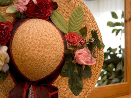 a wickerreath with flowers and a hat with a ribbon at Landhotel Grimmeblick in Winterberg