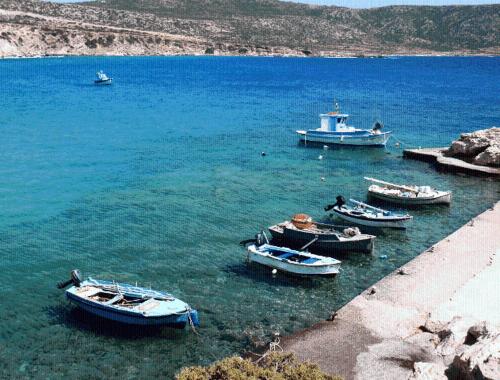 a group of boats in the water near a beach at Vardes Hotel Studios in Amoopi