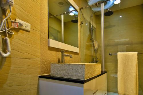 ein Bad mit einem Waschbecken und einem Spiegel in der Unterkunft Dawn Of Tarot B&B in Taitung