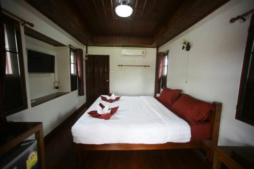 a bedroom with a white bed with flowers on it at Good Home@Udon Thani Resort in Ban Nong Khun