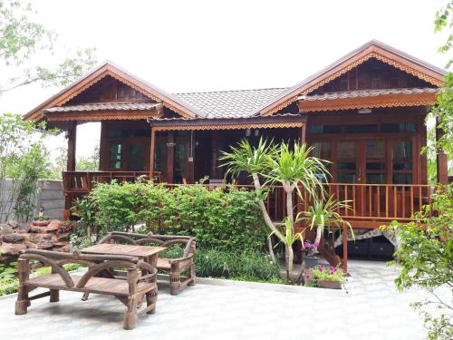 a house with two wooden benches in front of it at Good Home@Udon Thani Resort in Ban Nong Khun