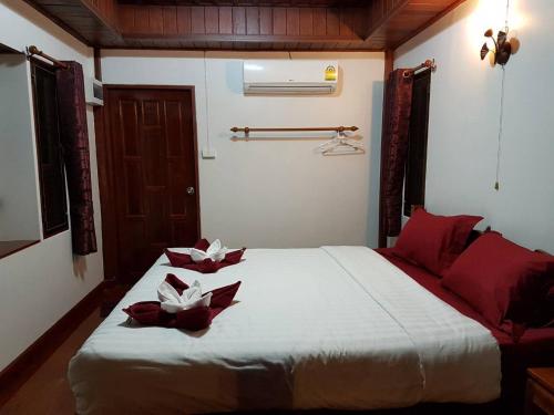 um quarto com uma cama com flores vermelhas e brancas em Good Home@Udon Thani Resort em Ban Nong Khun