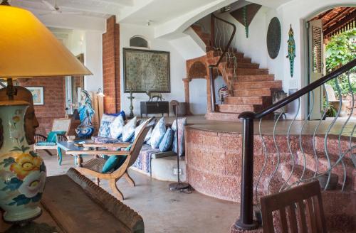 a living room with a couch and a staircase at Ahilya By The Sea in Nerul