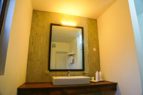 a bathroom with a sink and a mirror at Miyura Holiday Bungalow in Kandy