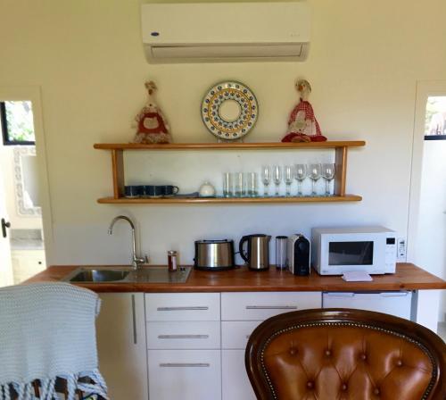 a kitchen with a sink and a microwave at The Garden Cottage at The Olives in Yankalilla
