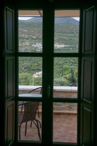 a view through a window of a table and chair at Traditional Apartments Plagiaki in Neon Oitilon