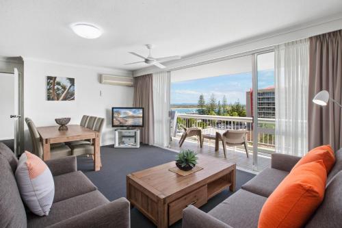 a living room with a couch and a large window at Port Pacific Resort in Port Macquarie