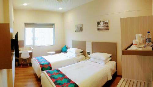 a hotel room with two beds and a window at Ginger Mumbai, Andheri in Mumbai