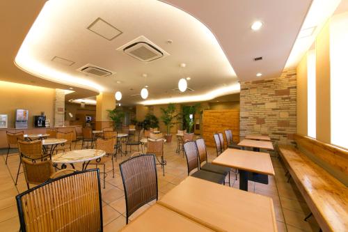 a dining room with tables and chairs in a restaurant at R&B Hotel Umeda East in Osaka
