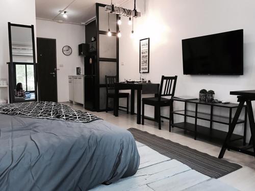 a bedroom with a bed and a table and a television at Stay in Style at Nimman R208 in Chiang Mai