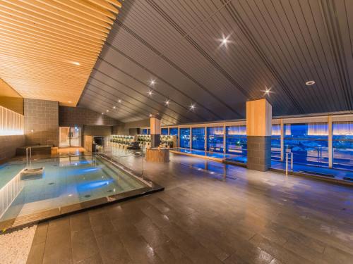 a large indoor swimming pool in a building at Grandia Housen in Awara