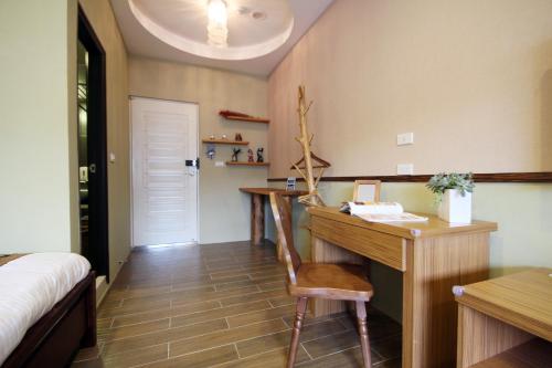 a bedroom with a desk and a bed and a desk at Bei Yue B&B in Luodong