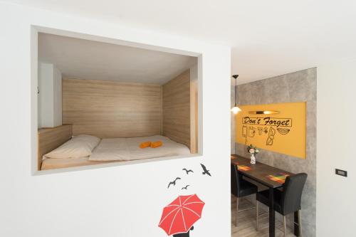 a small bedroom with a bed and a table at Apartment Mango in Sarajevo