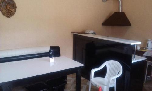 Zimmer mit einem Tisch, einem Stuhl und einem Schreibtisch in der Unterkunft Guest House Shavnabada in Ambrolauri