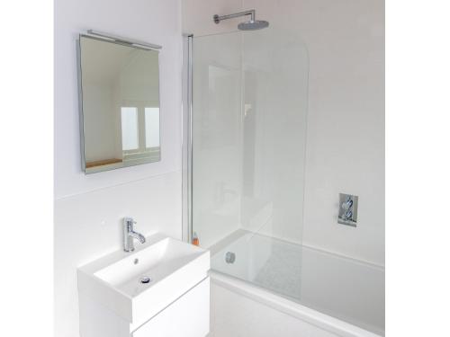 La salle de bains blanche est pourvue d'un lavabo et d'une douche. dans l'établissement Laurel Studio, à Aldeburgh