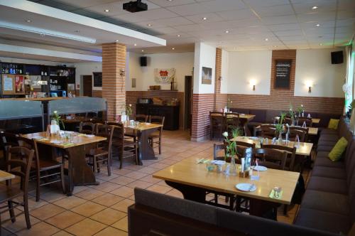 a restaurant with wooden tables and chairs in a room at Akazienhof Hotel & Brauhaus in Cologne