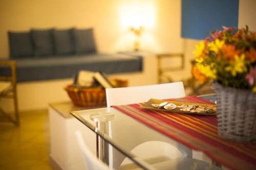 a room with a table with a vase of flowers at Grace's Place in Scopello