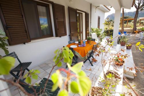 a patio with a table and chairs on a house at Grace's Place in Scopello