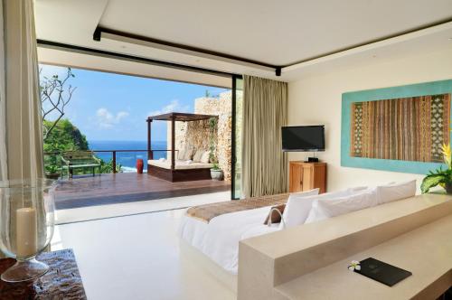 a bedroom with a bed and a view of the ocean at The Ungasan Clifftop Resort in Uluwatu