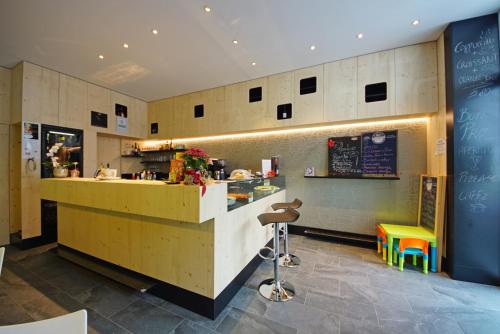 a fast food restaurant with a counter and a bench at Alpin Relais B&B Villa Melisse in Colfosco