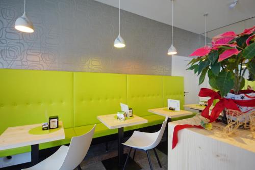 a restaurant with two tables and a green wall at Alpin Relais B&B Villa Melisse in Colfosco