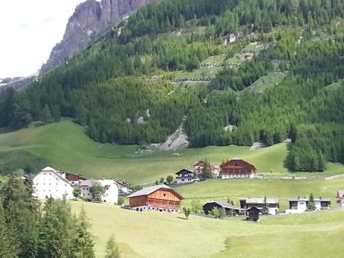 a small village on a hill with a mountain at Alpin Relais B&B Villa Melisse in Colfosco