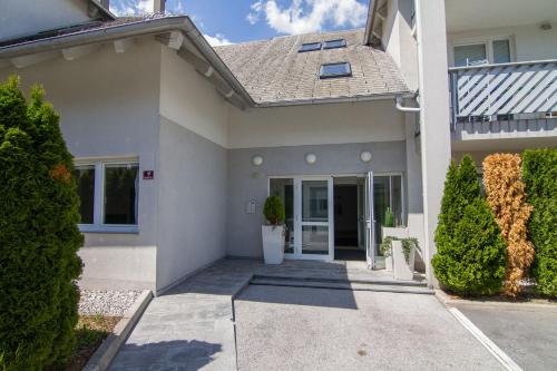 a white house with a driveway at Apartments Taci in Bled