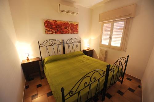 アレッサーノにあるcase vacanza''Antonuccio''のベッドルーム1室(緑色のベッド1台、2泊用スタンド付)