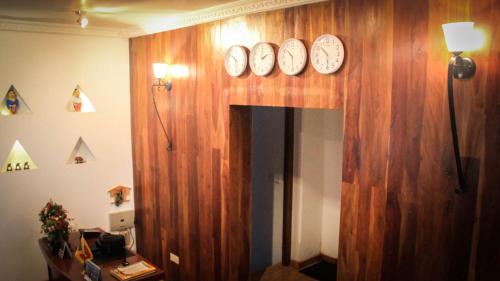 a hallway with clocks on a wooden wall at Airport Green Olive Villa in Katunayaka