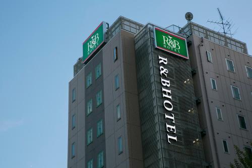 a building with two street signs on top of it at R&B Hotel Nagoya Nishiki in Nagoya