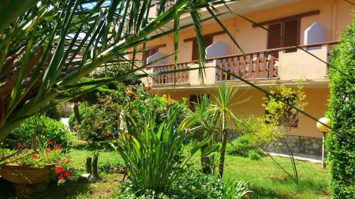 a garden in front of a building with plants at Frank's Hotel in Capoliveri