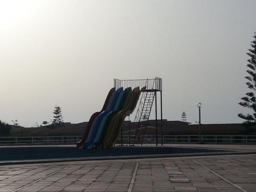 a slide in a park with a playground at El Zohour Chalet North Coast in El Alamein