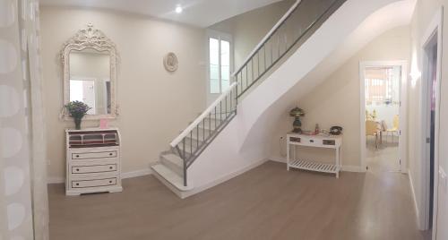 a hallway with a staircase with a dresser and a mirror at Manzil Cordoba in Córdoba