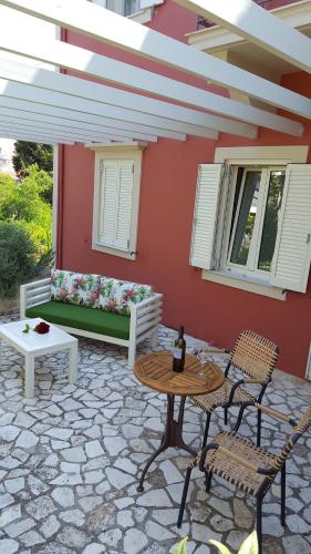 a patio with a couch and a table and chairs at Magnolia Apartments in Fiskardho