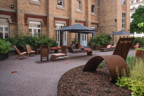 a courtyard with chairs and umbrellas in front of a building at Ciarus in Strasbourg