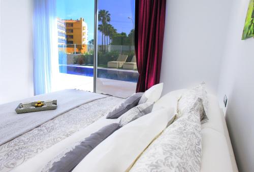 a bed in a room with a large window at Villas Flamingo Resort in Adeje