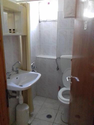 a white bathroom with a sink and a toilet at Amarantos in Loutra Amarantou