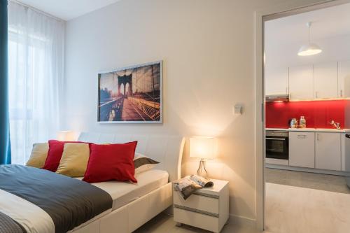 a small bedroom with a bed and a kitchen at Apartment Dąbrowskiego by The Railway Station Wroclaw in Wrocław
