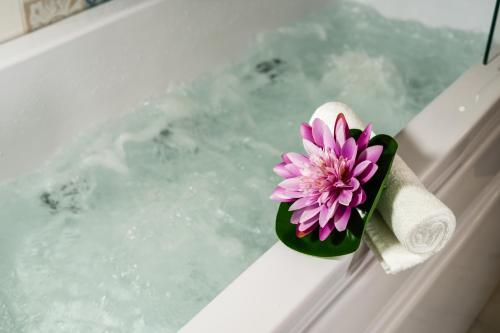 a purple flower in a green holder on a bath tub at Fior di Loto Sweetness in Cagliari