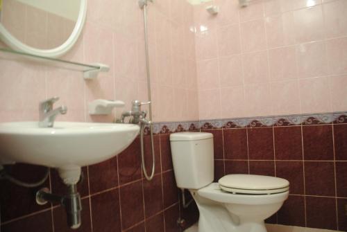 a bathroom with a toilet and a sink at Hoang Trang Hotel in Da Lat